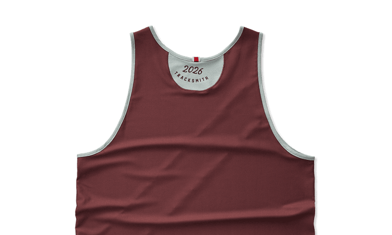 Maroon running vest with white trim, designed for track and field athletes, featuring the year 2026 and Tracksmith branding.