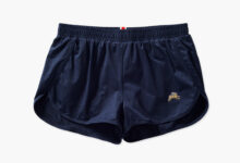 Navy blue running shorts with a small gold logo on the left leg, designed for comfort and performance during running activities.