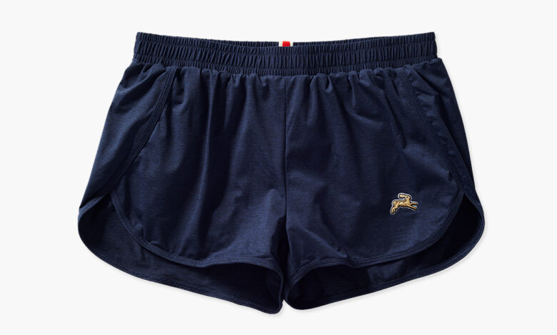 Navy blue running shorts with a small gold logo on the left leg, designed for comfort and performance during running activities.