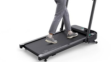 Woman using a high-tech treadmill for running and workout at home or gym, with a focus on fitness and exercise.