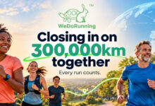 Group of diverse runners participating in a running event with a city skyline and a digital globe in the background, promoting community and global running efforts.