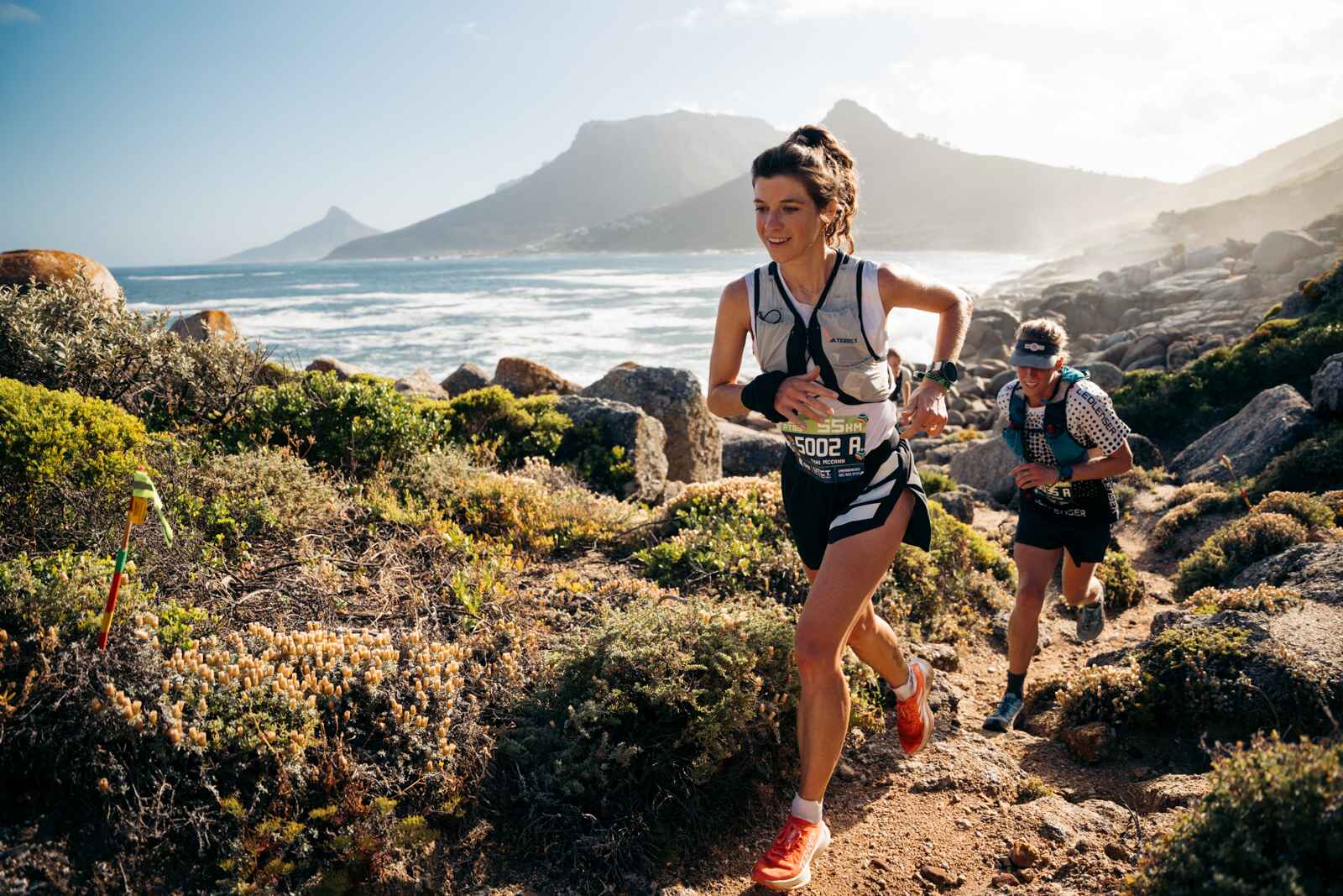 Trail runners on a coastal mountain path near Cape Town
