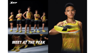 Young male athlete showcasing yellow and black running shoes for performance and style, with a professional studio background.