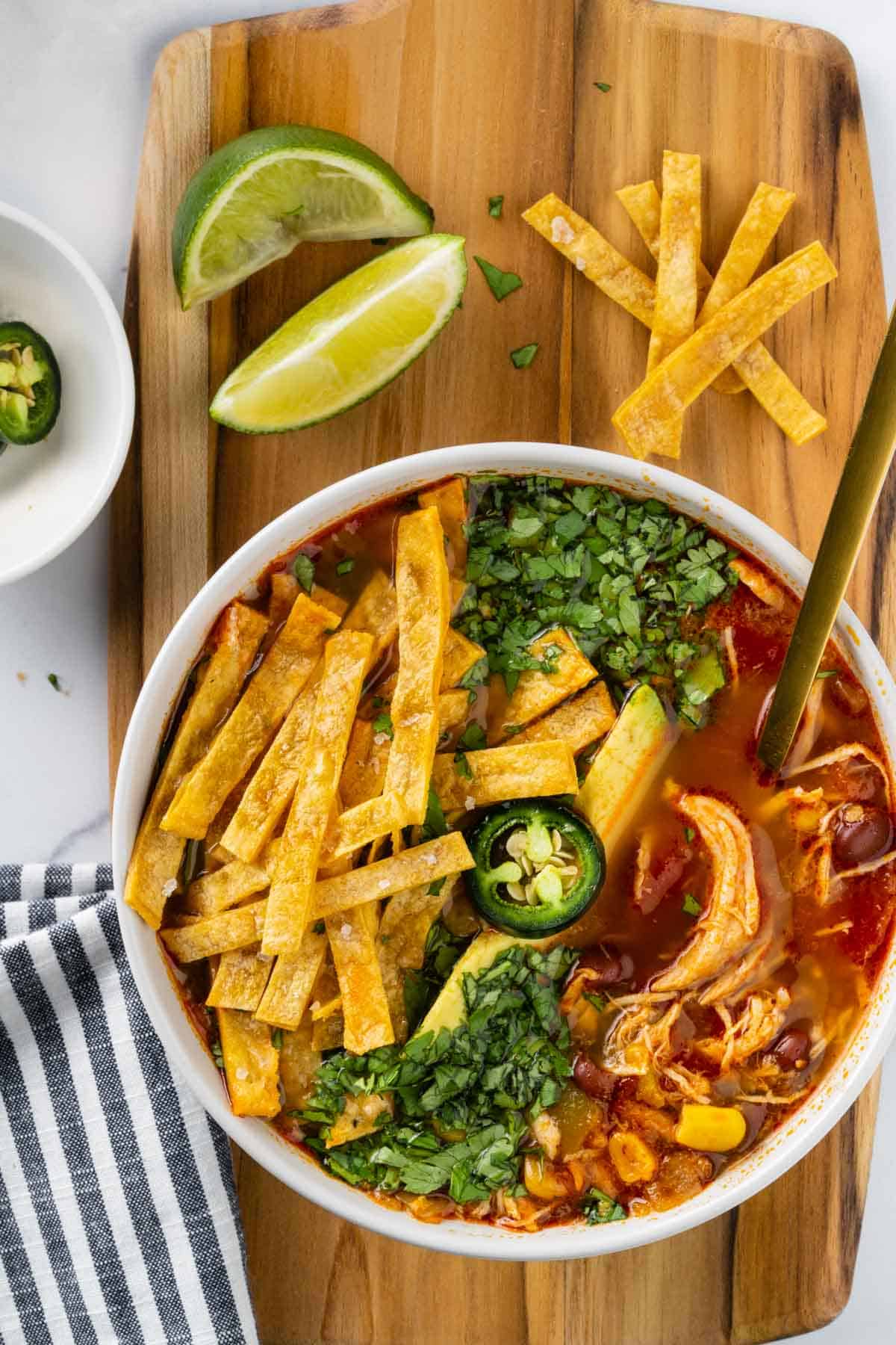 bowl of instant pot chicken tortilla soup with toppings.