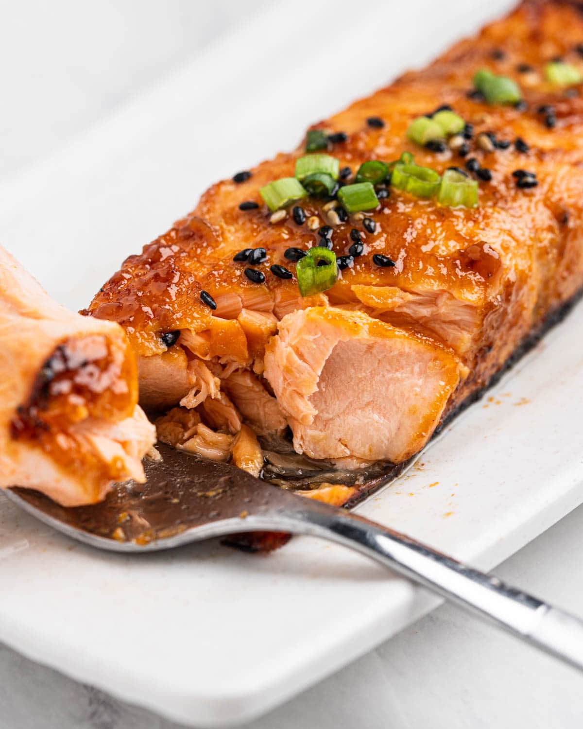 Close up bite shot of miso salmon and fork with a piece.