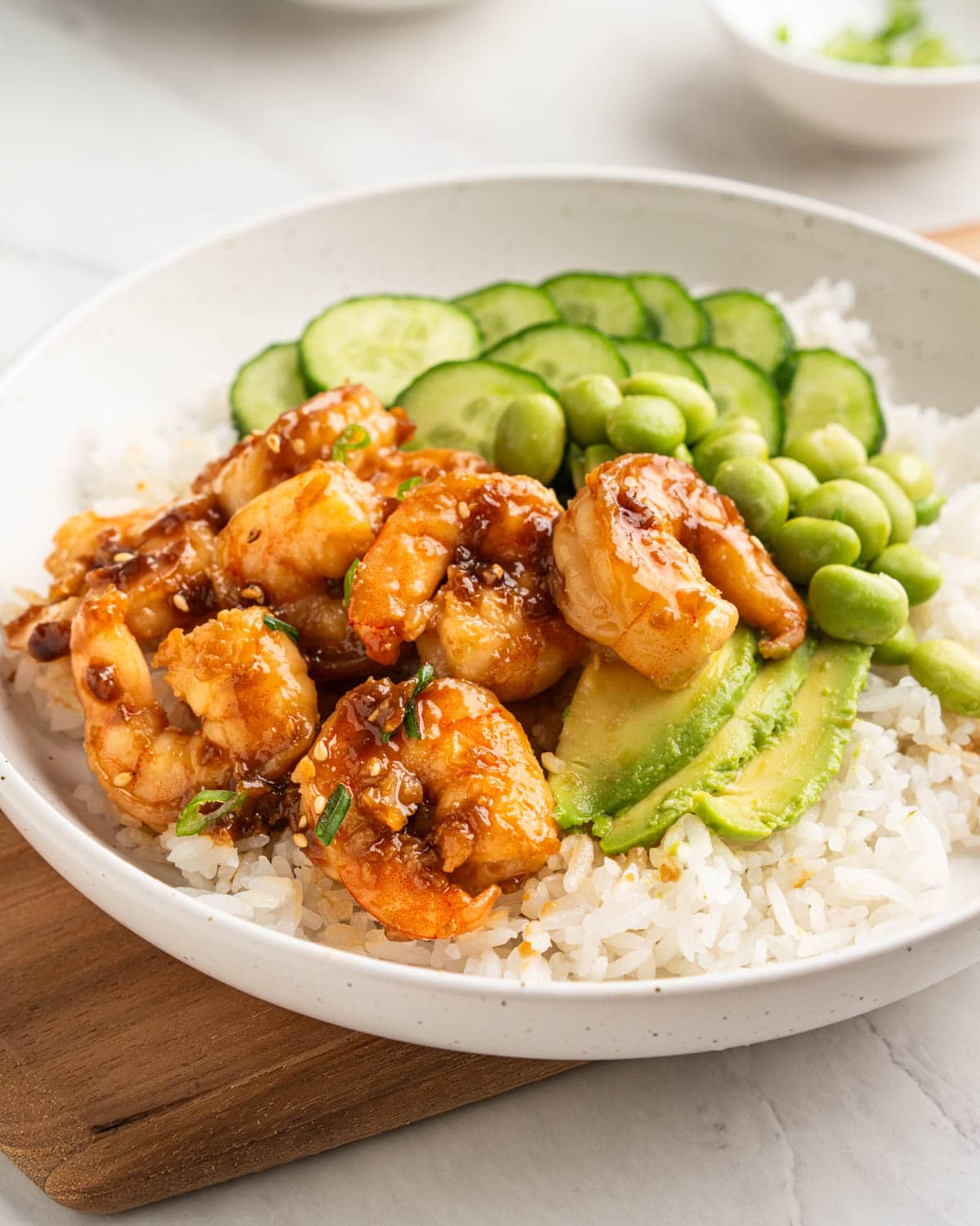 close up of honey garlic shrimp over plate of rice.
