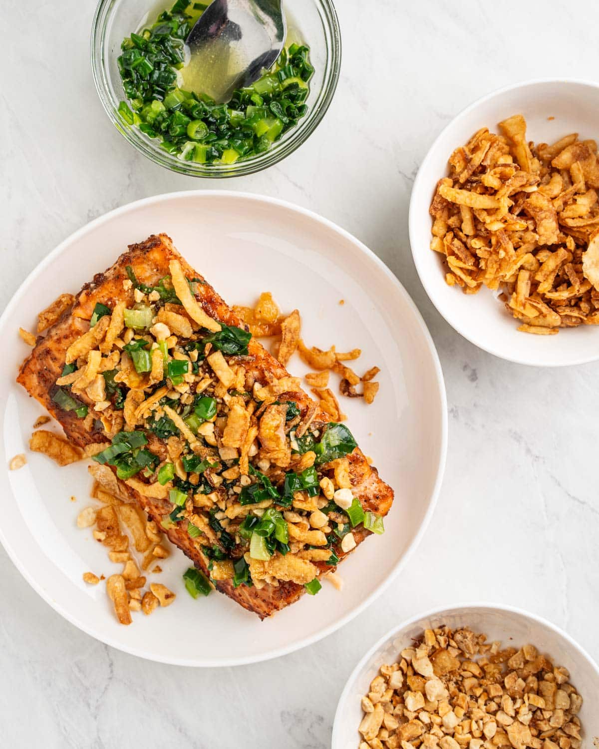 Baked salmon topped with crushed peanuts, scallion oil and fried onions.