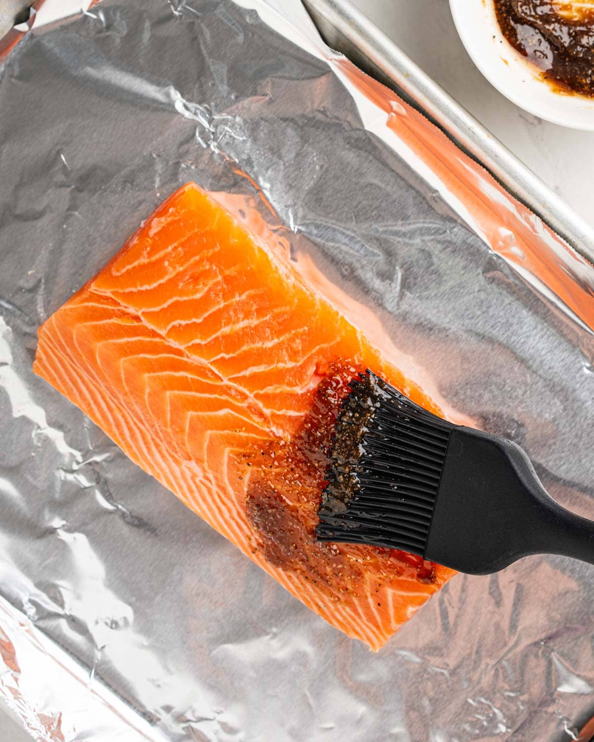 brushing salmon with seasoning.