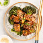 plate of teriyaki chicken and broccoli over white rice.