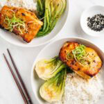 two plates of miso cod with rice and baby bok choy.