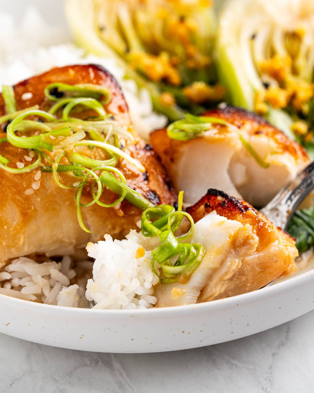 close up of miso cod and rice on fork.