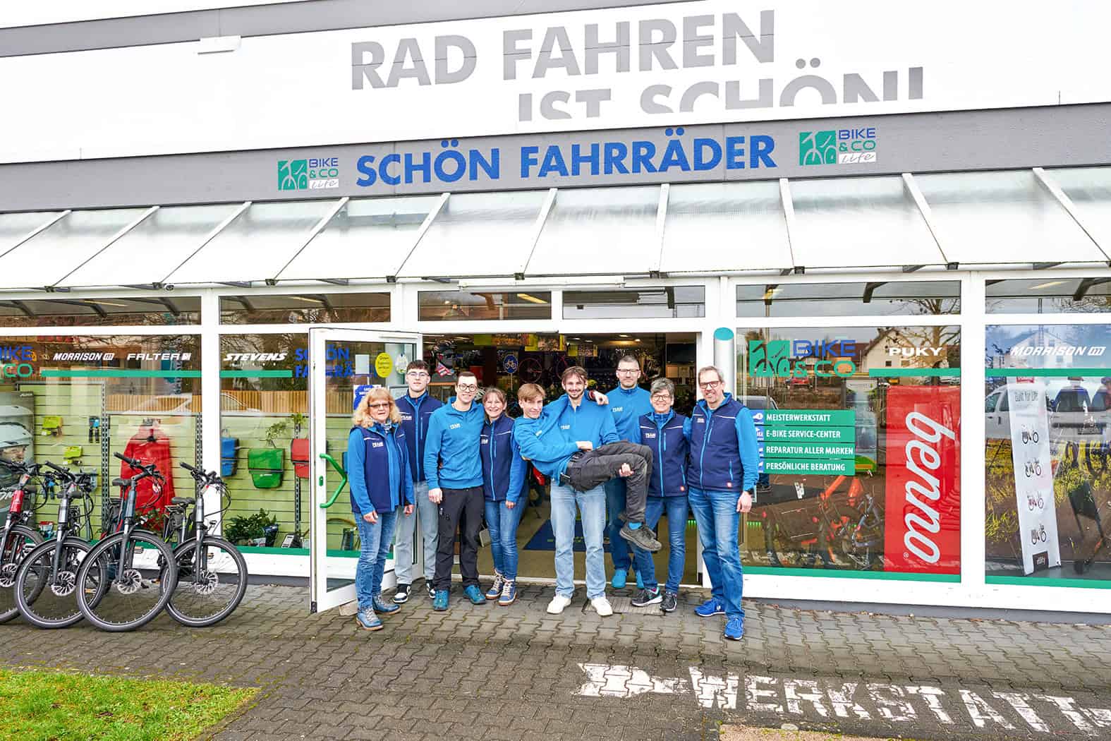 Schön Fahrräder in Gau-Algesheim Team von Fahrradgeschäft vor Laden mit Fahrrädern und Logo.