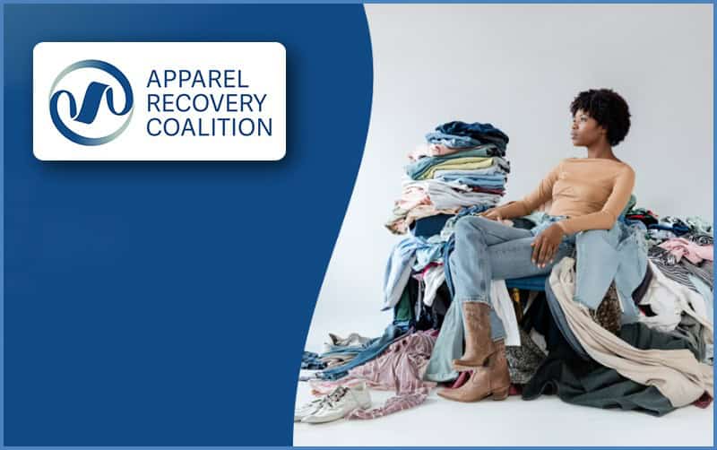 Woman sitting among piles of clothes for textile waste recovery.