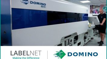 Large Domino digital printing press in a printing facility with operator.
