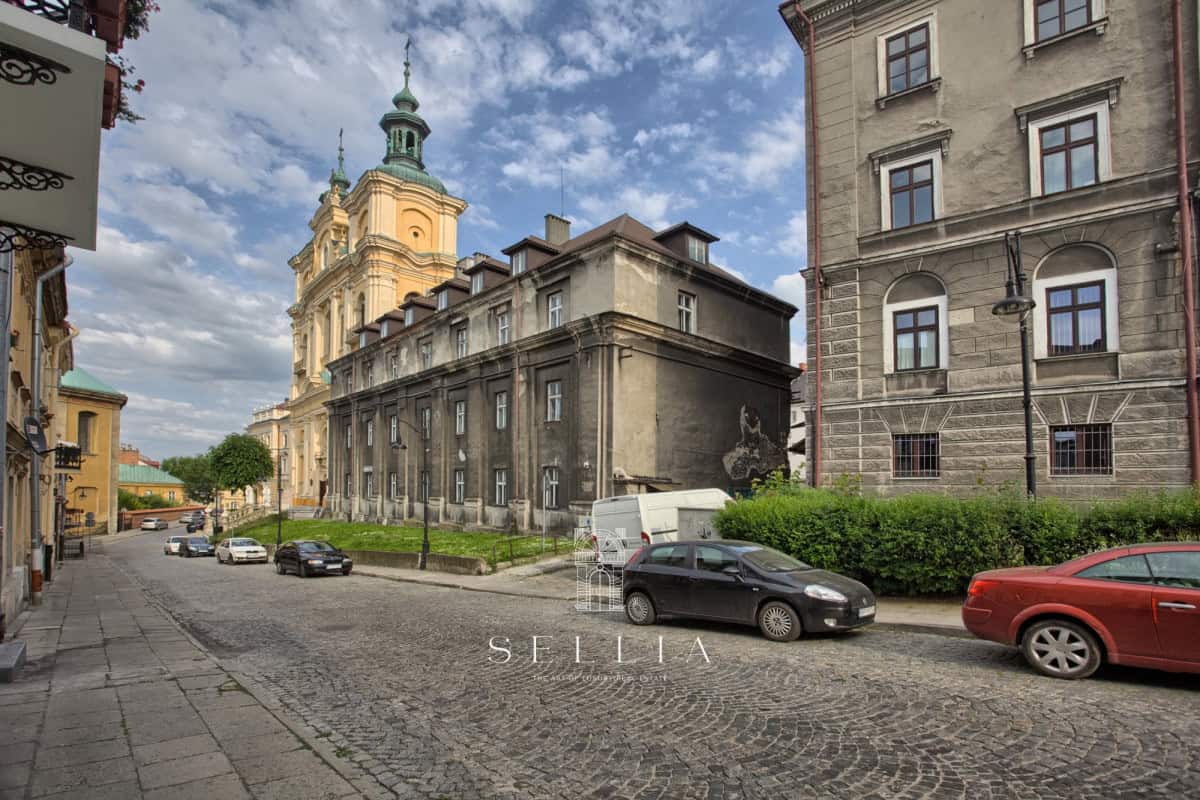 Historyczna kamienica w centrum Przemyśla z widokiem na kościół.