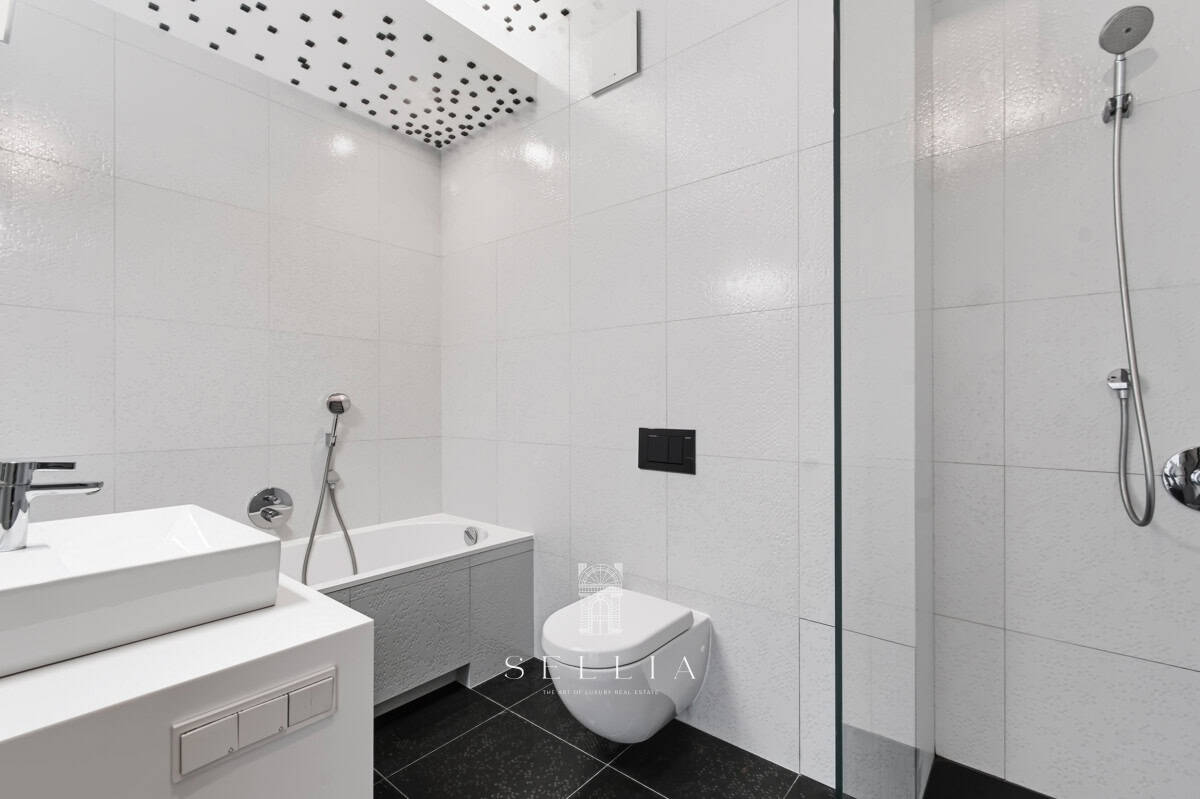 Elegancka łazienka z prysznicem i wanną w luksusowym apartamencie.