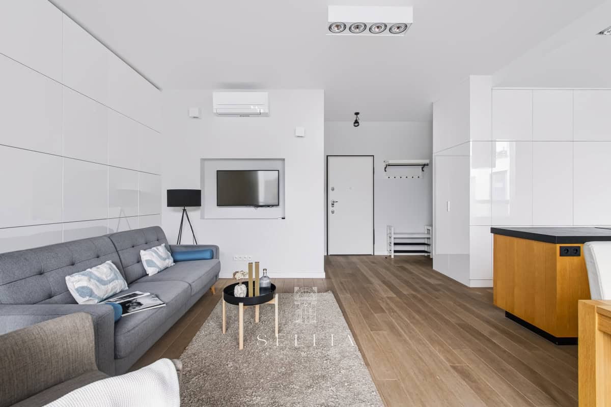 Nowoczesny, jasny salon w luksusowym apartamencie z tarasem.