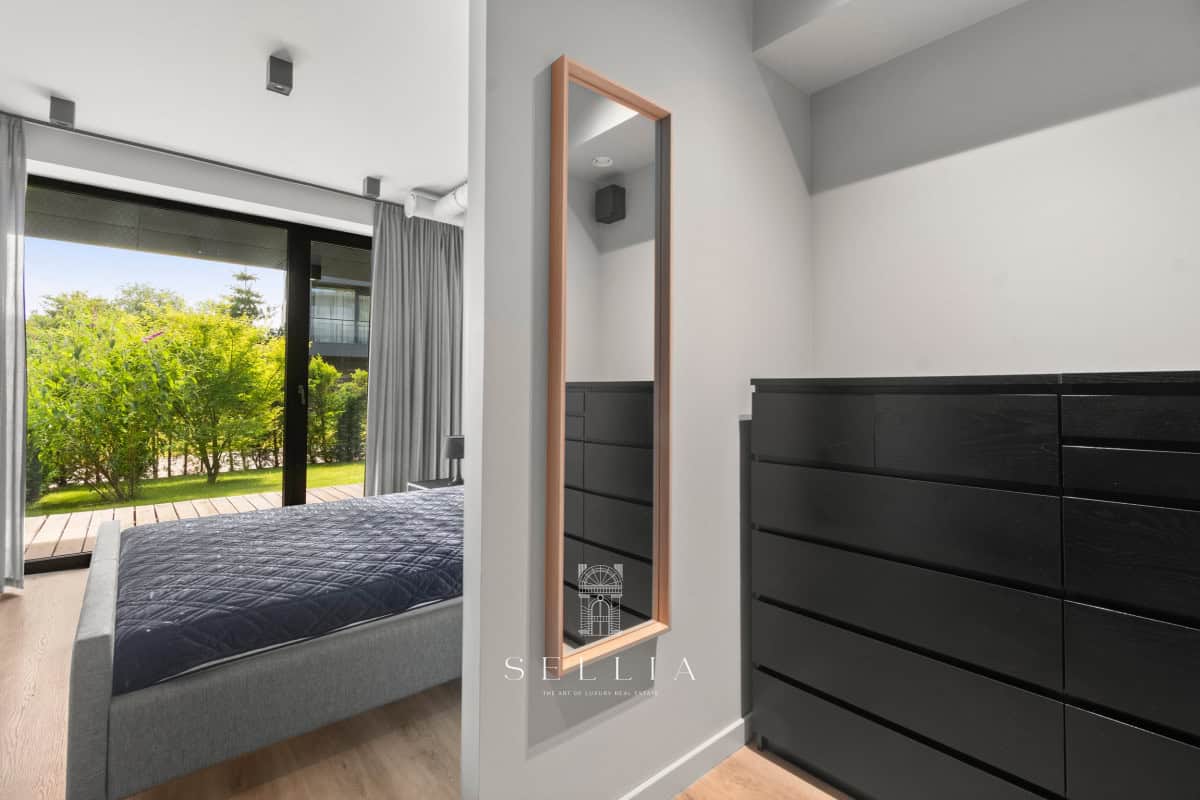 Przestronny apartament z dużym oknem i widokiem na zieleń.