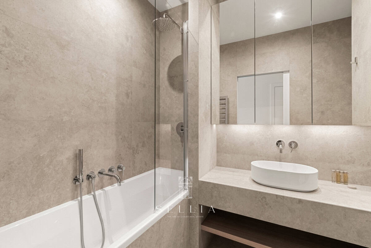 Elegancka łazienka z wanną i dużym lustrem w apartamencie.