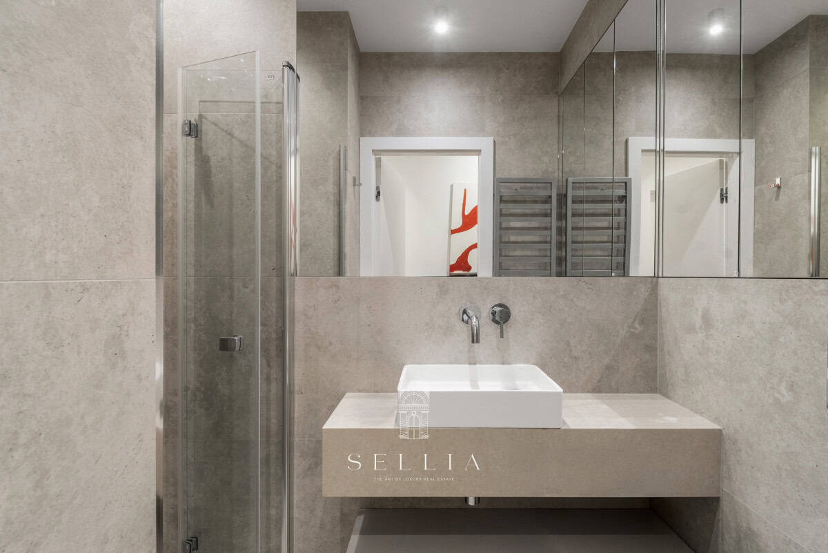 Elegancka łazienka z dużym lustrem i umywalką w Sellia Estate.