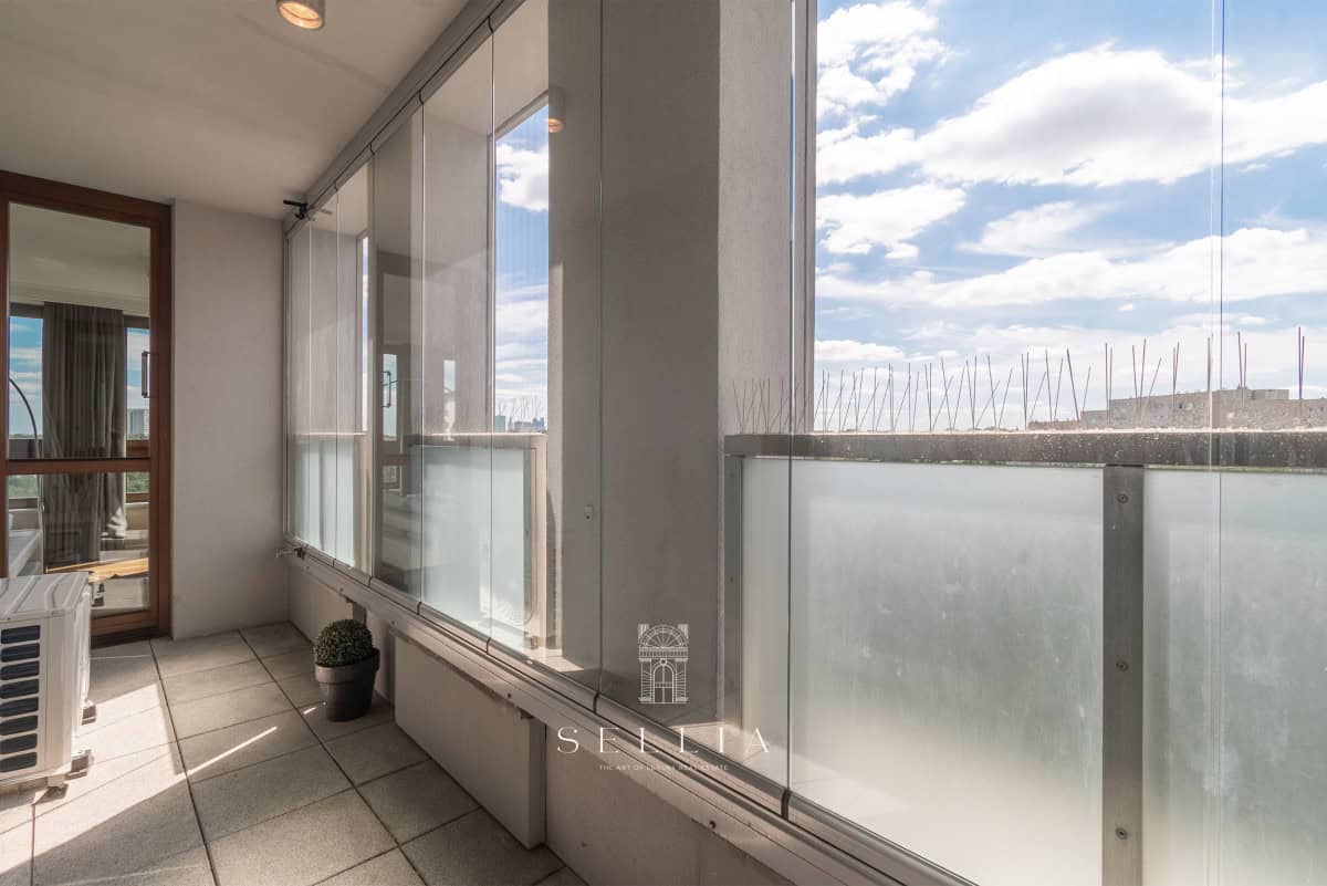 Przestronny balkon z panoramicznym widokiem na park w Żoliborzu.