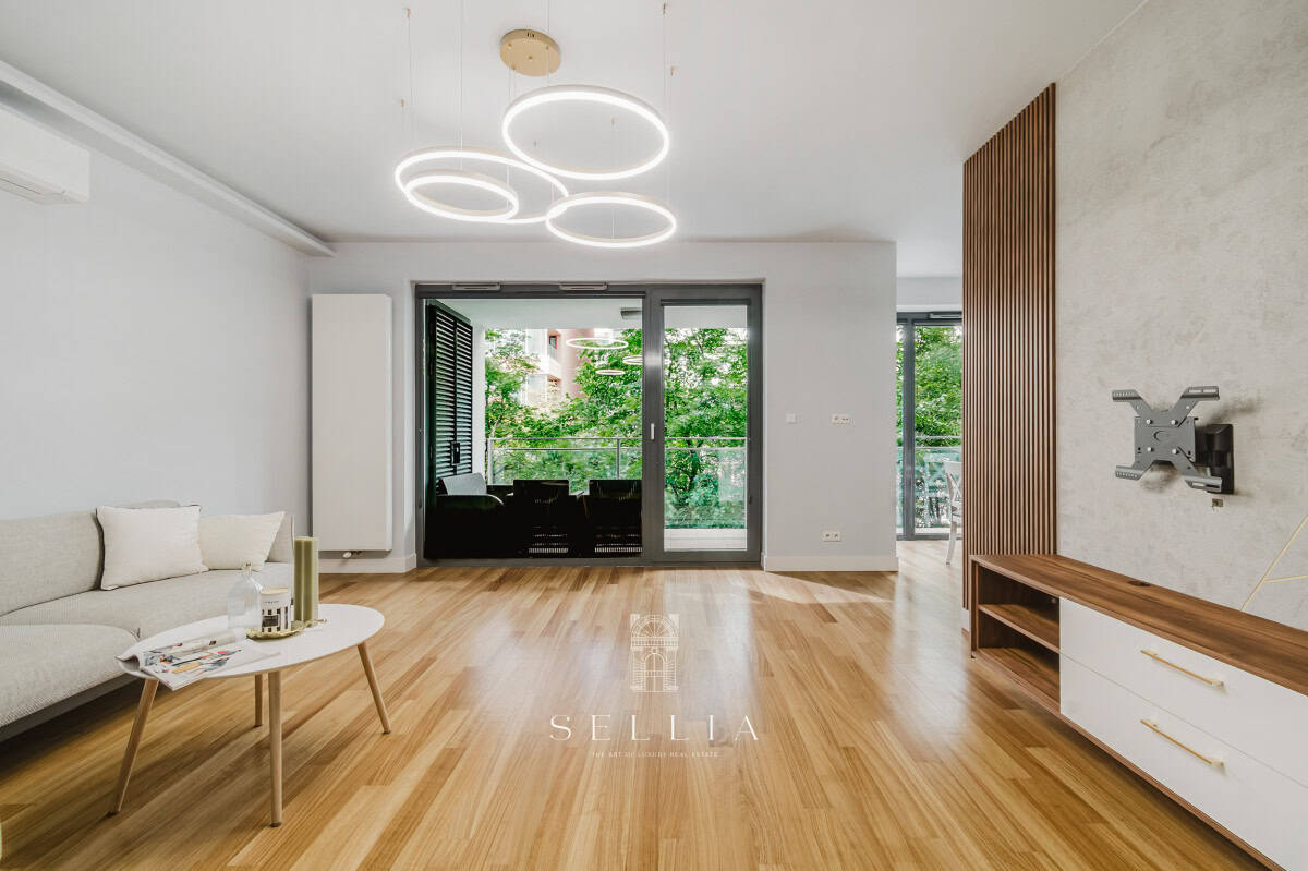 Przestronny, nowoczesny salon z dużymi oknami i balkonem.