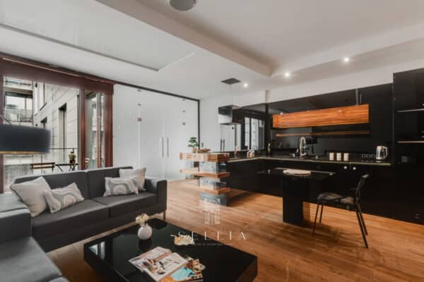 Przestronne nowoczesne mieszkanie z kuchnią i salonem, duże okno, naturalne światło, elegancki wystr.