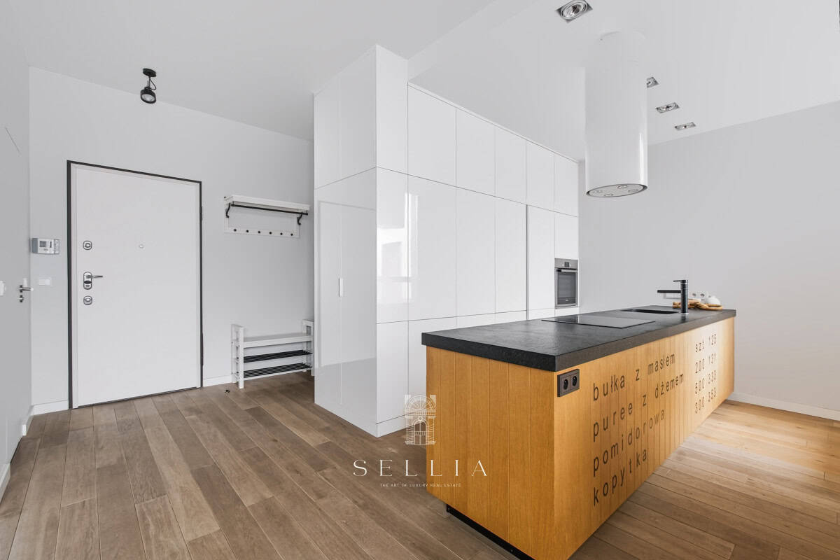 Przestronna kuchnia w nowoczesnym apartamencie z tarasem i minimalistycznym designem.