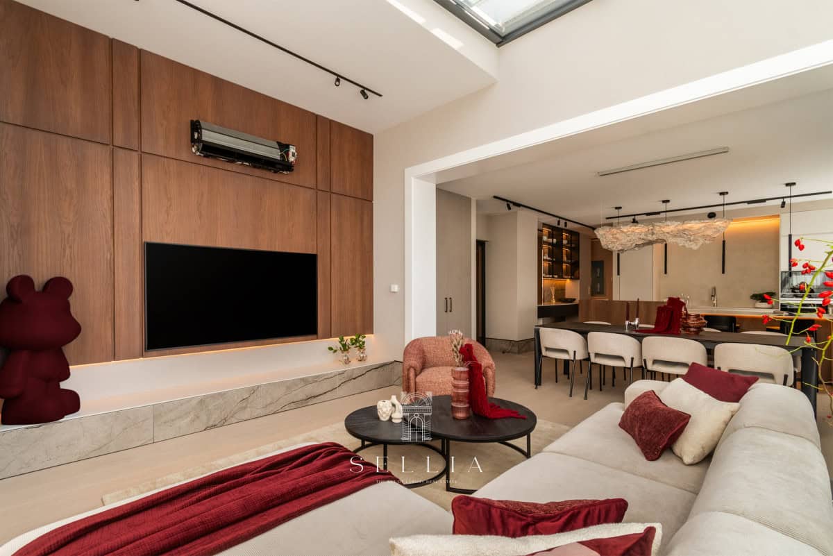 Przestronny salon w penthousie z nowoczesnym wykończeniem i dużym ekranem TV.