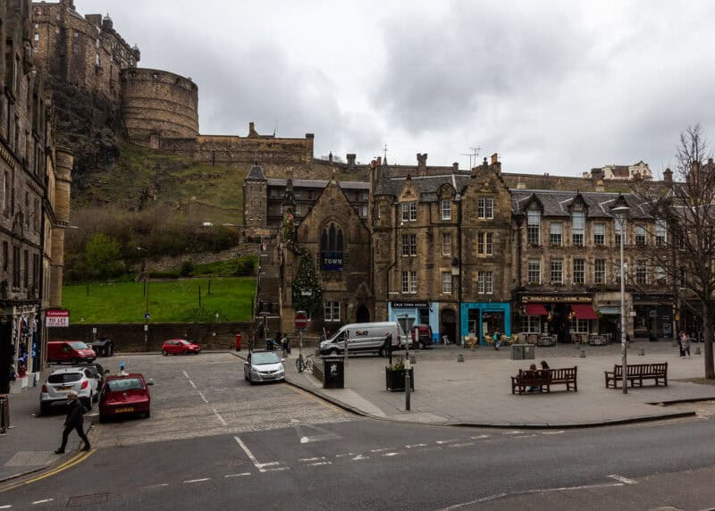 Exterior view of the hostel with historic stone buildings and a castle on the hill behind. at St Christopher's Edinburgh Old Town hostel