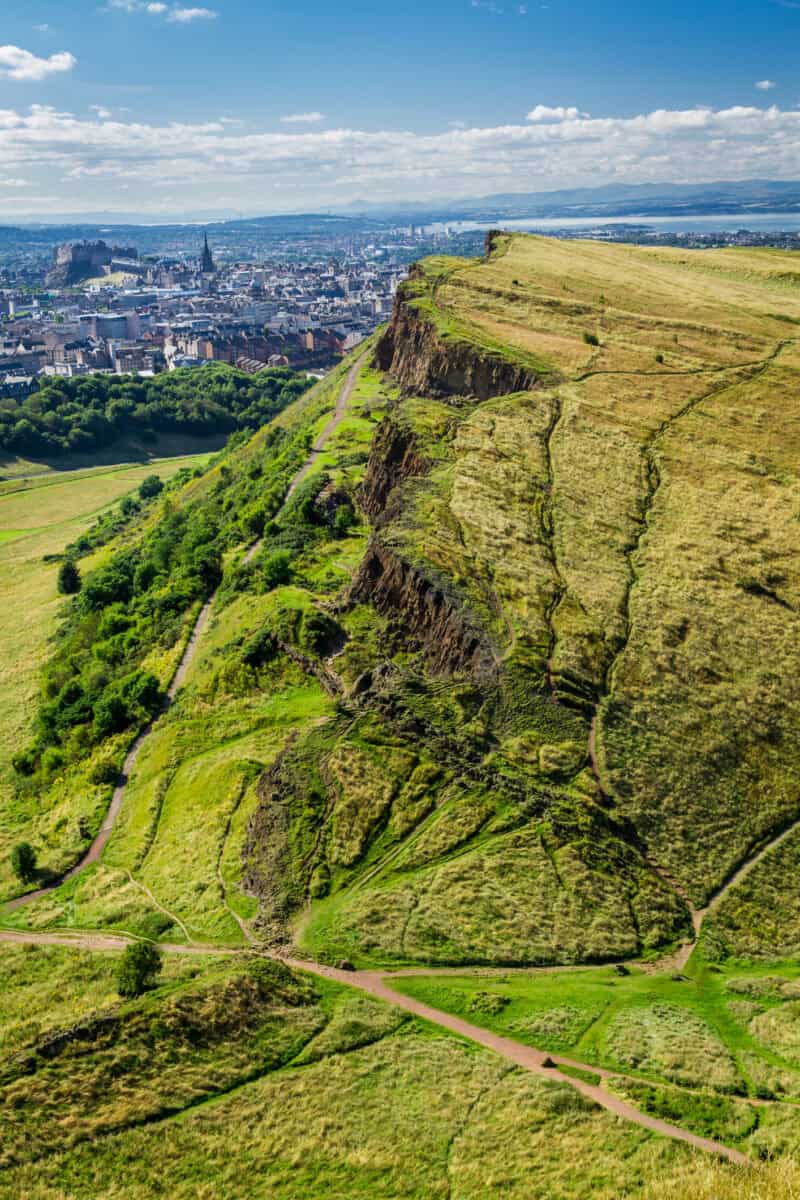 View of Arthur's Seat with grassy slopes and paths, overlooking the city skyline. at St Christopher's Edinburgh Old Town hostel