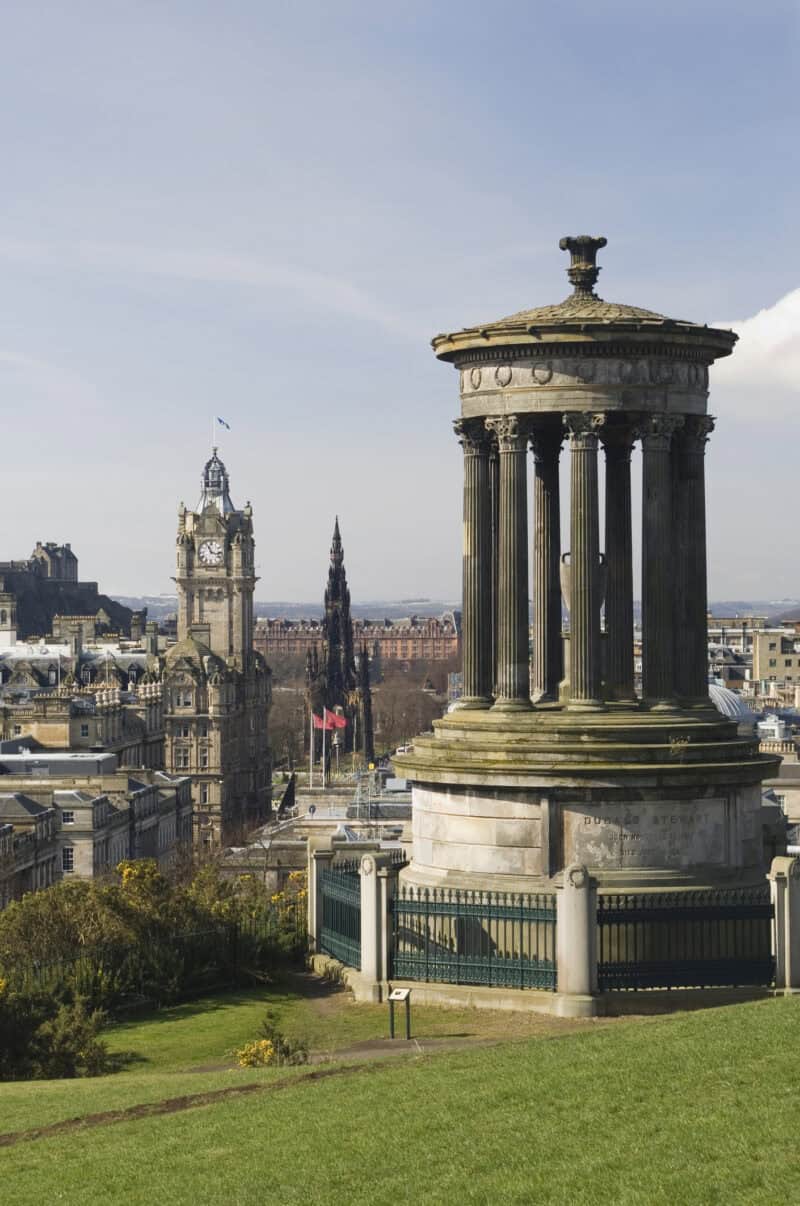 View of the Calton Hill monument with cityscape and clock tower in the background. at St Christopher's Edinburgh Old Town hostel