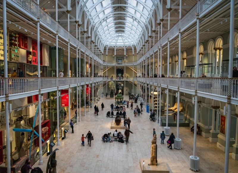 Victorian arcade with glass roof and multiple levels, shoppers walking and shops on both sides. at St Christopher's Edinburgh Old Town hostel