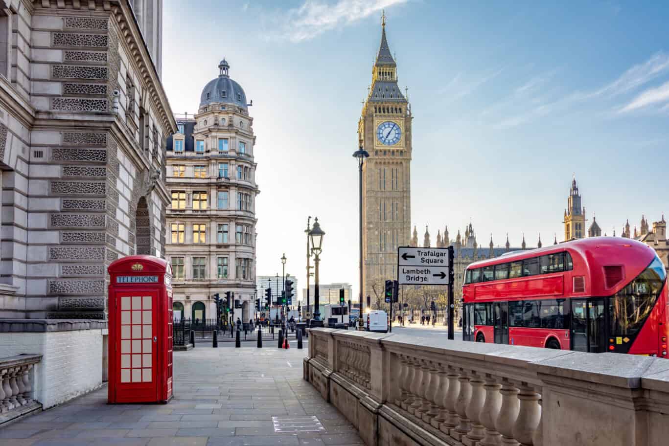 City street scene with historic buildings, a red telephone box, and a double-decker bus.