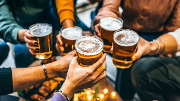 A group of friends clinking pints at The Hercules Pillars in Holborn, a pub showing Formula 1 live in central London