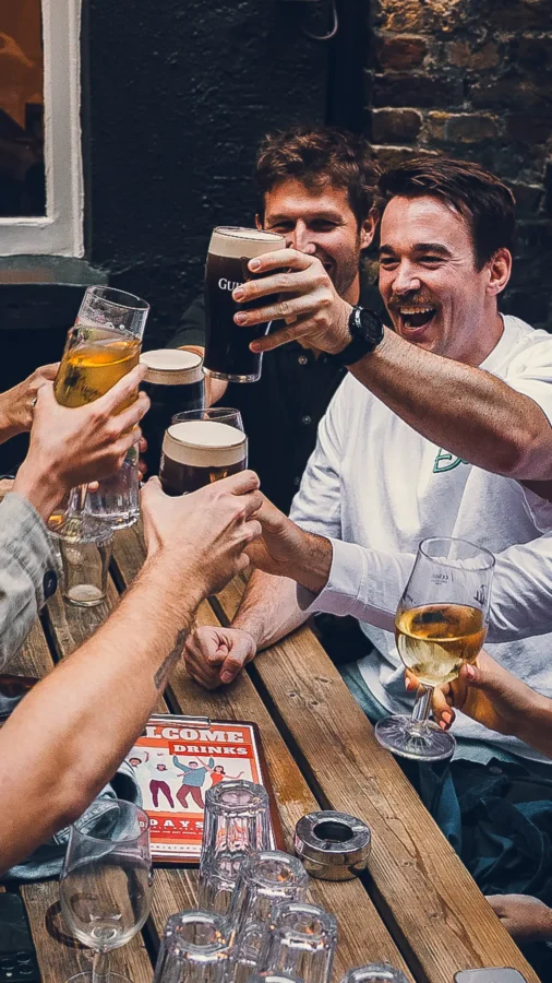 Friends raising glasses outside St Christopher's Pub, a historic pub in London Bridge on Borough High Street