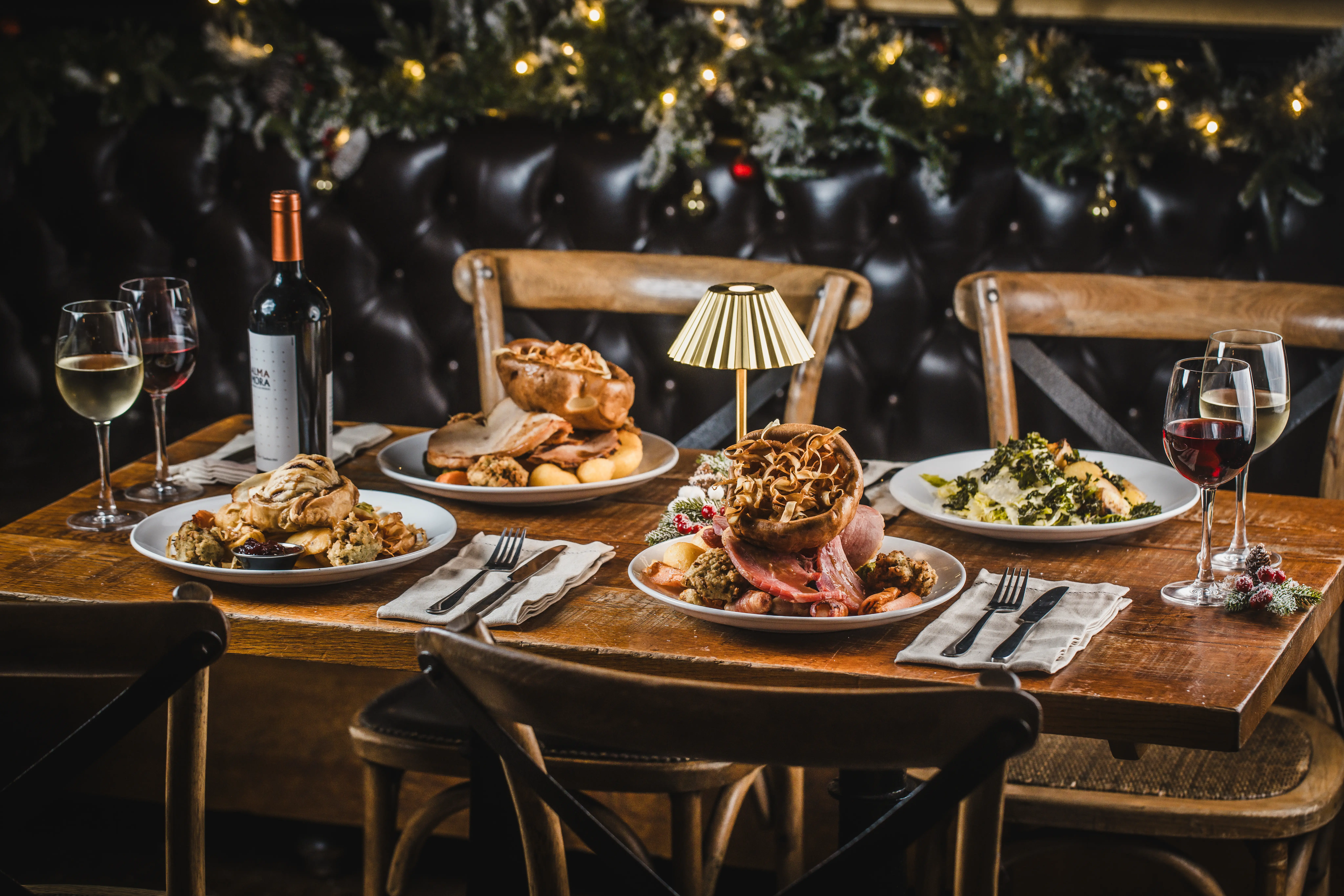 A festive table set with Christmas roast dishes and wine at St Christopher's Pub, Borough High Street, London Bridge