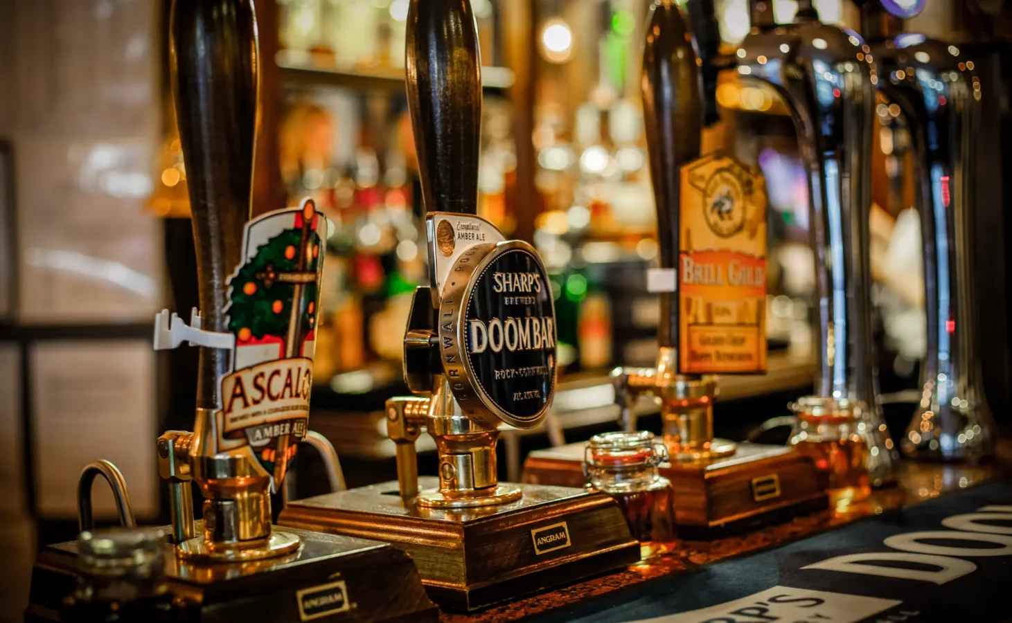 Real ale pump handles including Sharp's Doom Bar on the bar at St Christopher's Pub, Borough High Street, London Bridge