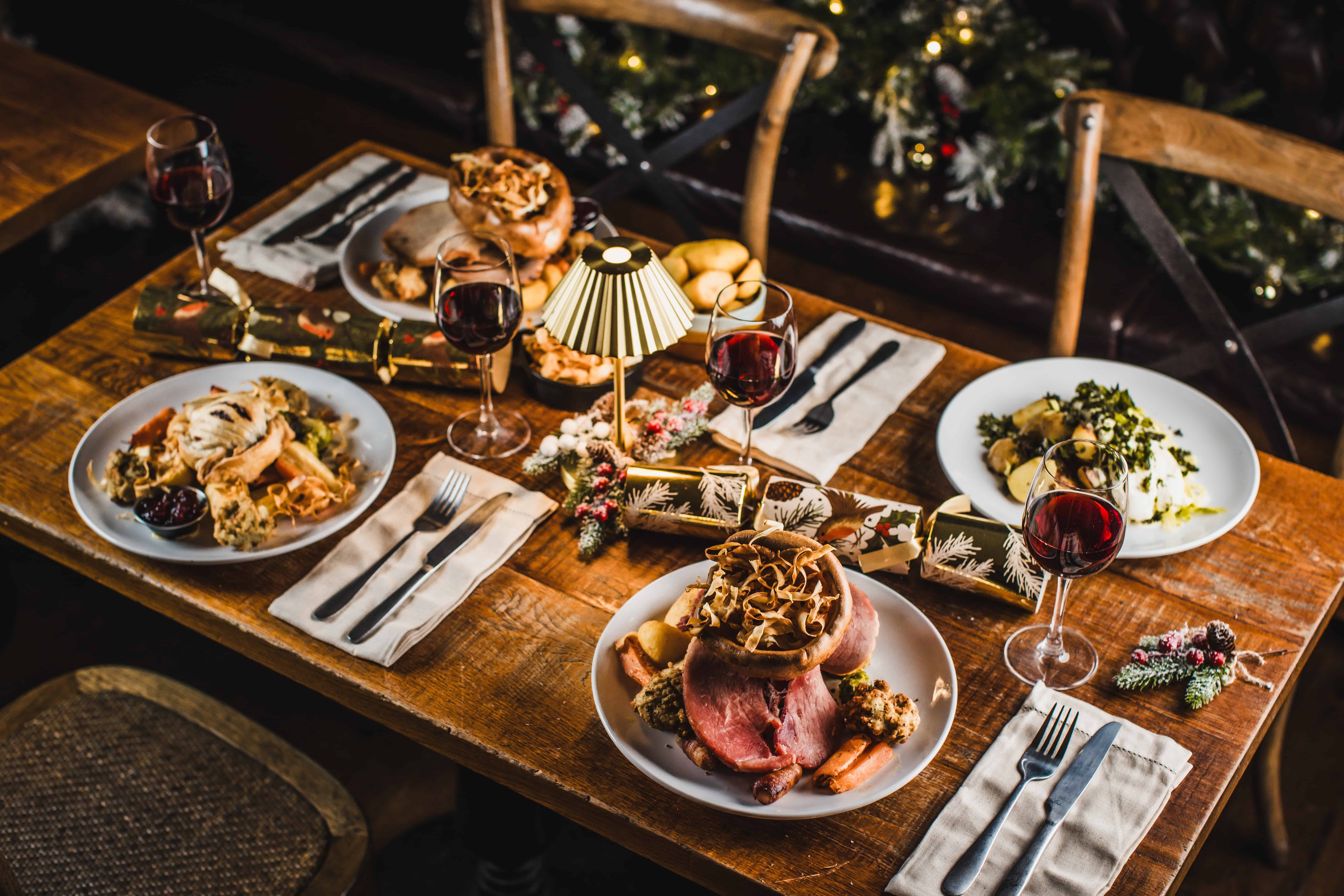 Festive dining setup at St Christopher's Pub with roast dinner and wine.