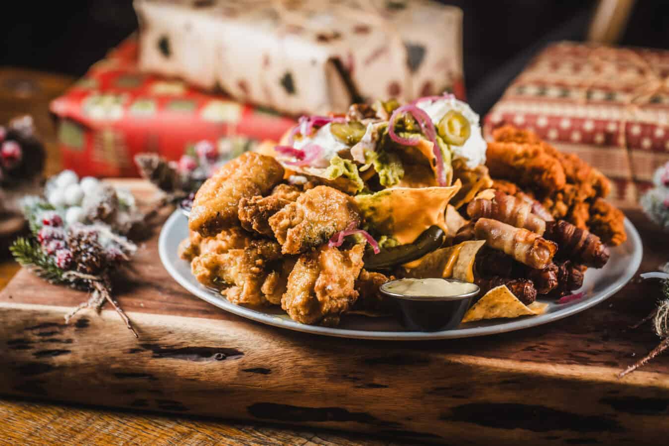 Delicious festive food platter at St Christopher's Pub with fried chicken, ribs, and sides.