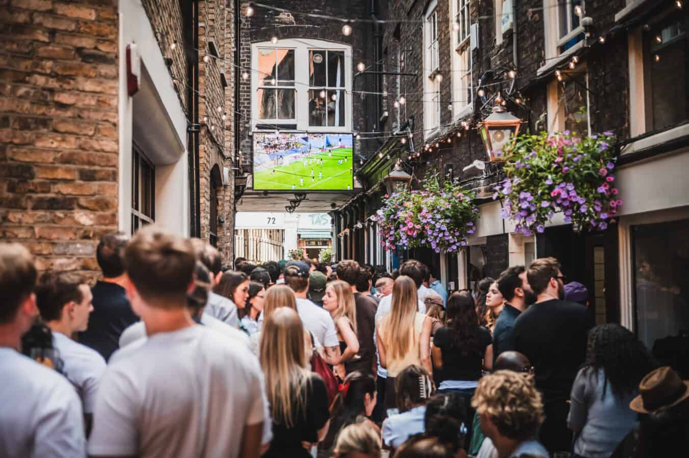 Crowd enjoying outdoor event at St Christopher's Pub in a narrow alleyway.
