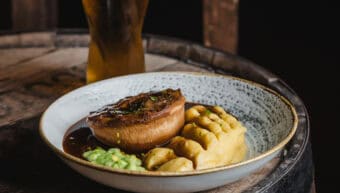 Gourmet meal with meat, mashed potatoes, and a glass of beer at St Christopher's Pub.