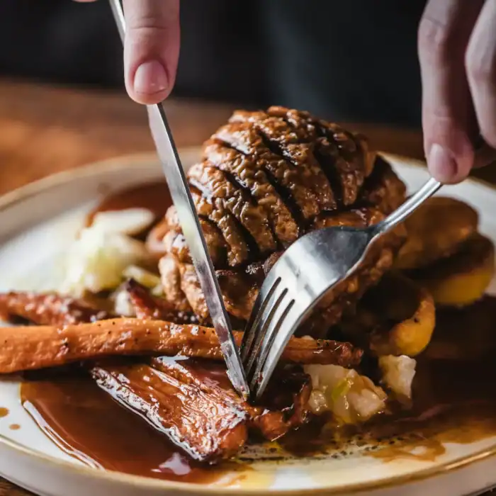 Close-up of a steak being cut with a knife and fork at St Christopher's Pub.