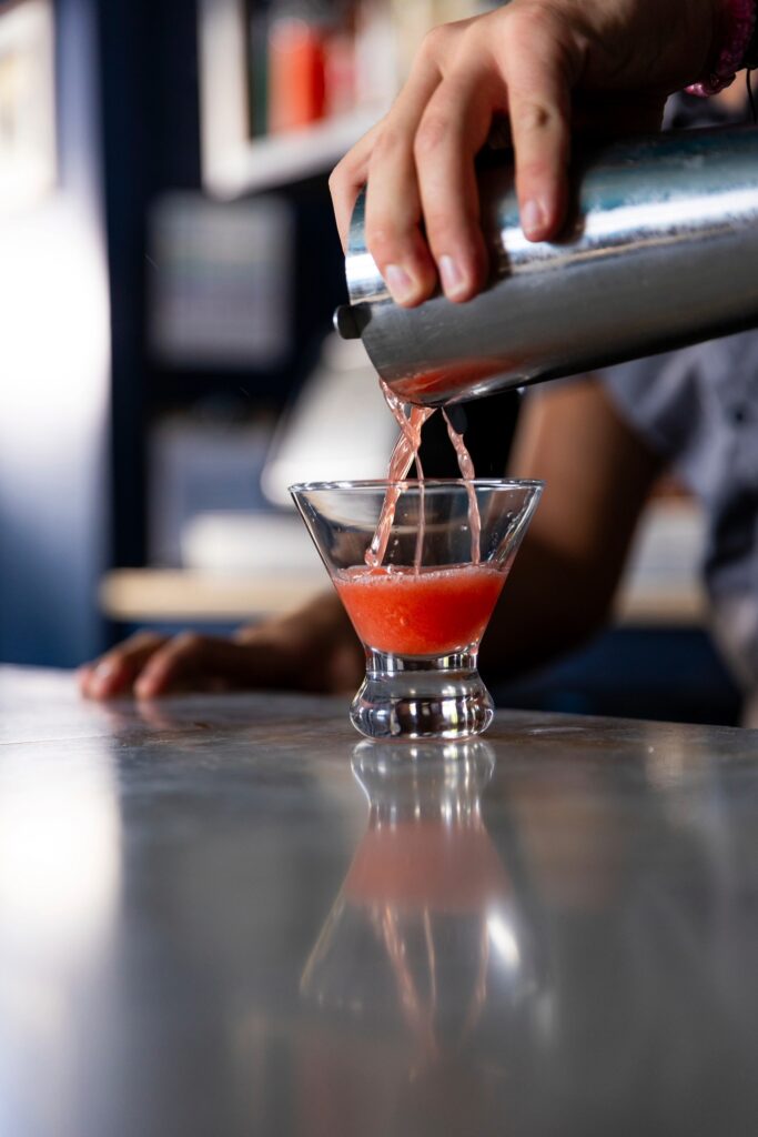 Bartender pouring a craft cocktail at The Chase Club bar