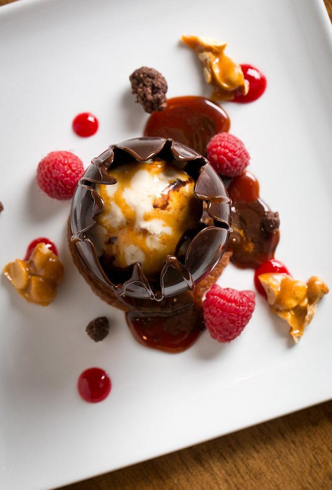 Chocolate dessert with raspberries and caramel drizzle plated at The Chase Club