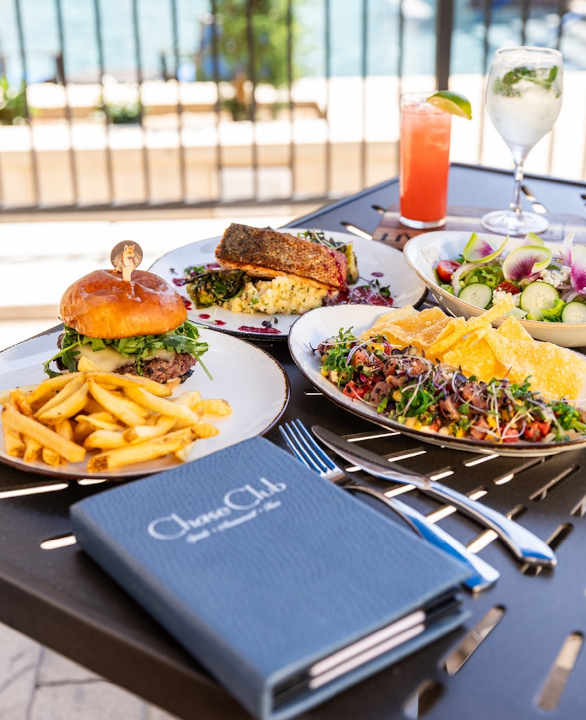 Burgers, fries, and salads served with cocktails at The Chase Club restaurant