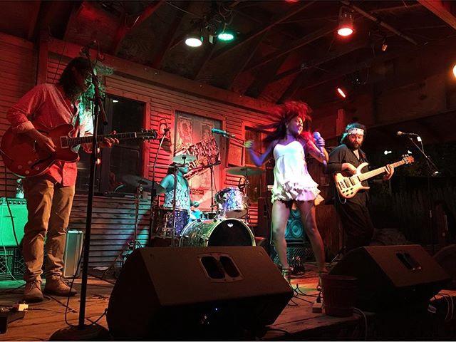Band performing live music under red stage lighting
