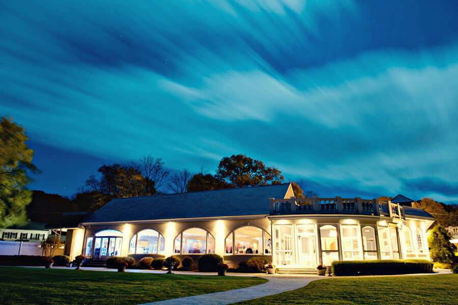 Candlewood Inn event venue illuminated at night with dramatic skies above the lake.
