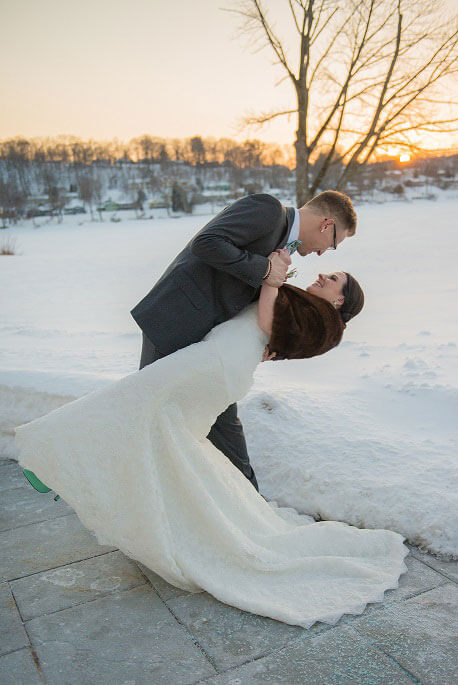 Joyous Moments Candlewood Inn winter wedding couple sharing a sunset kiss in the snow.