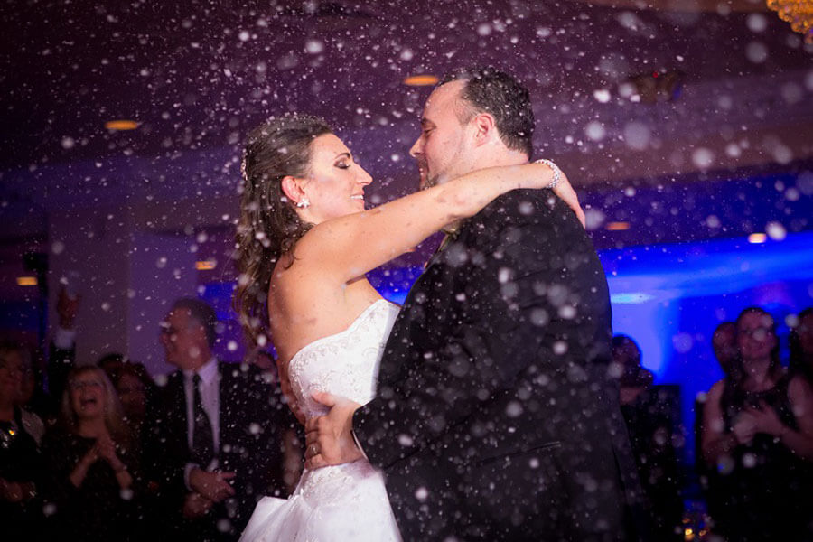 Melissa and Manny's wedding day first dance beneath a snowfall effect at Candlewood Inn.